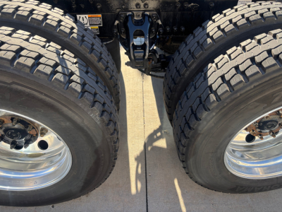Kenworth T680 truck rear drivetrain showing dual rear wheels and suspension components.