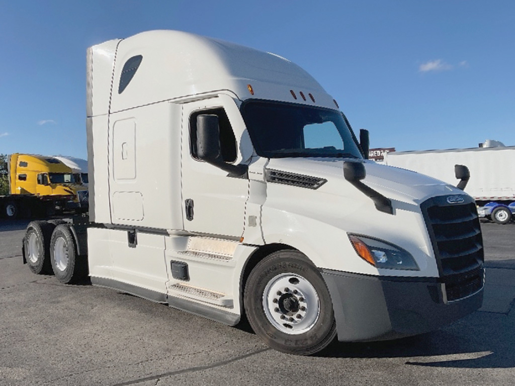 Truck cab of a white 2022 Freightliner Cascadia126 conventional sleeper with sleeper cab window and side steps, front grille visible.