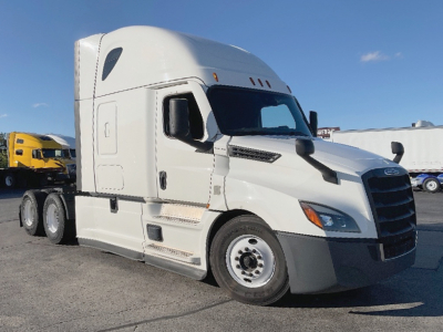 Truck cab of a white 2022 Freightliner Cascadia126 conventional sleeper with sleeper cab window and side steps, front grille visible.