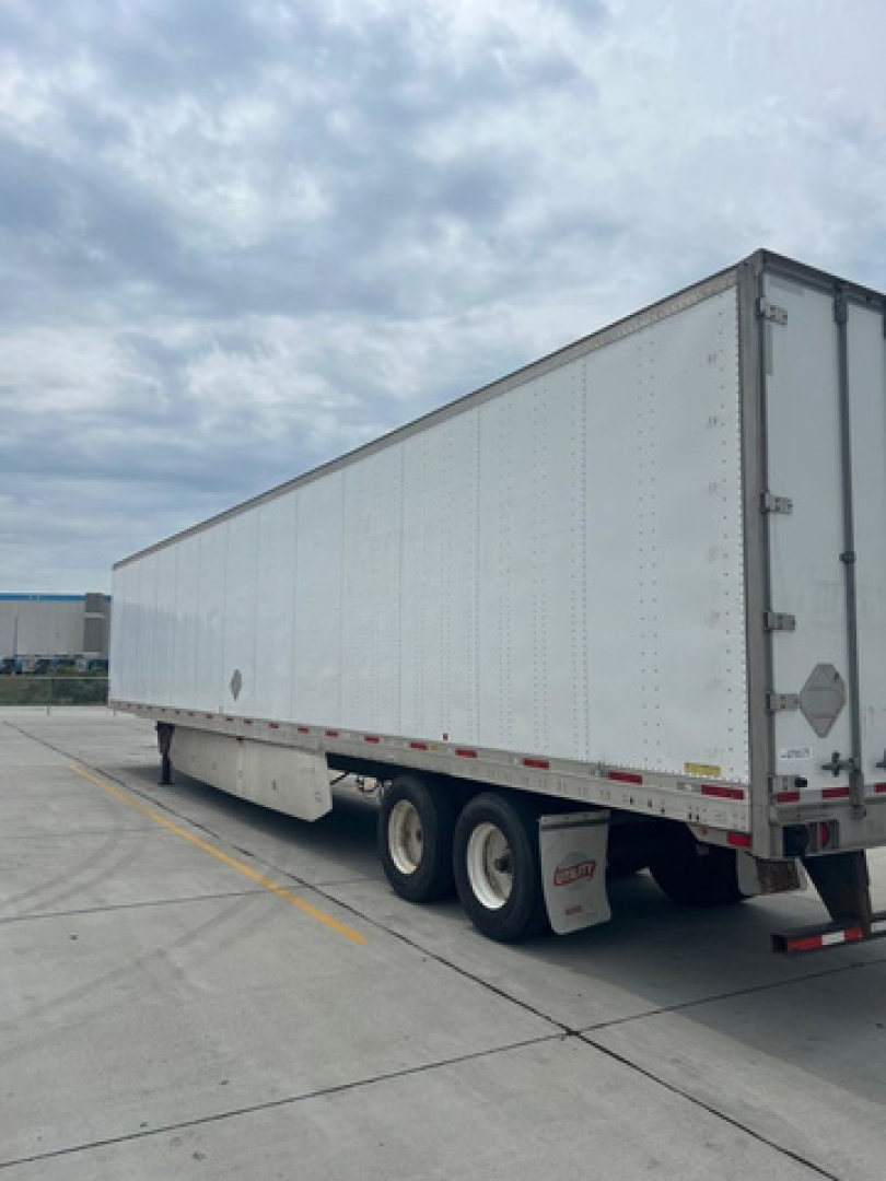 Trailer show side view of a utility van trailer with white panels and tandem axles.