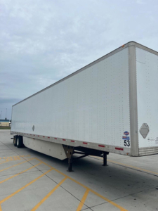 Utility van trailer with white exterior showing side view and landing gear.