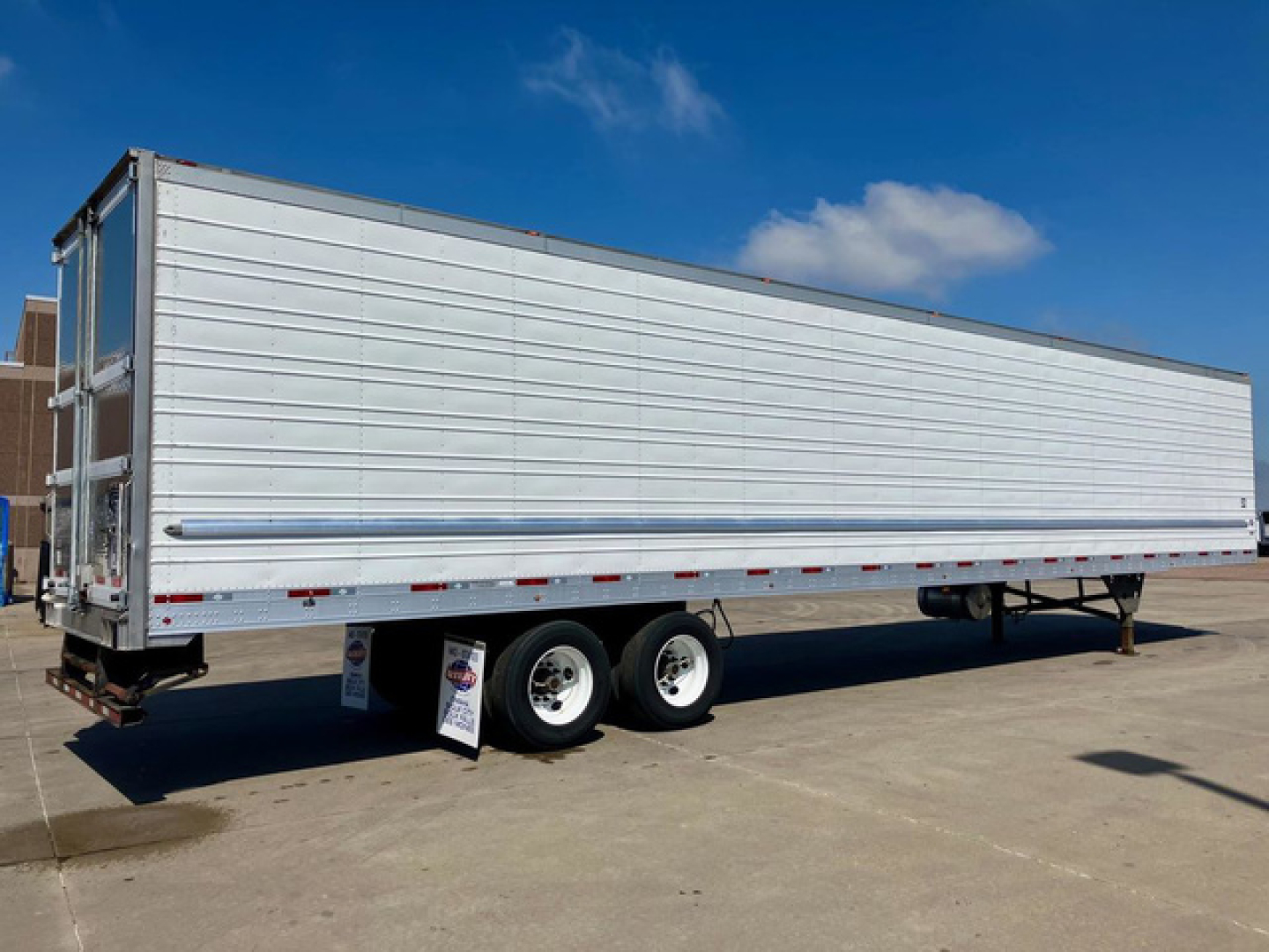 Utility reefer trailer shown in side view with tandem axles and white exterior panels.