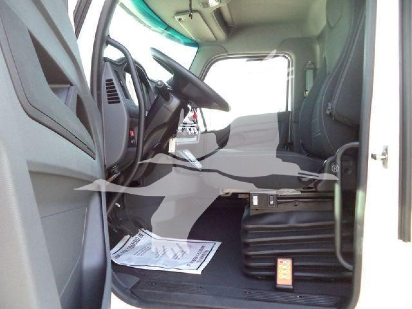 Kenworth T280 truck cab interior view from driver side showing steering wheel, dashboard, and entry area.
