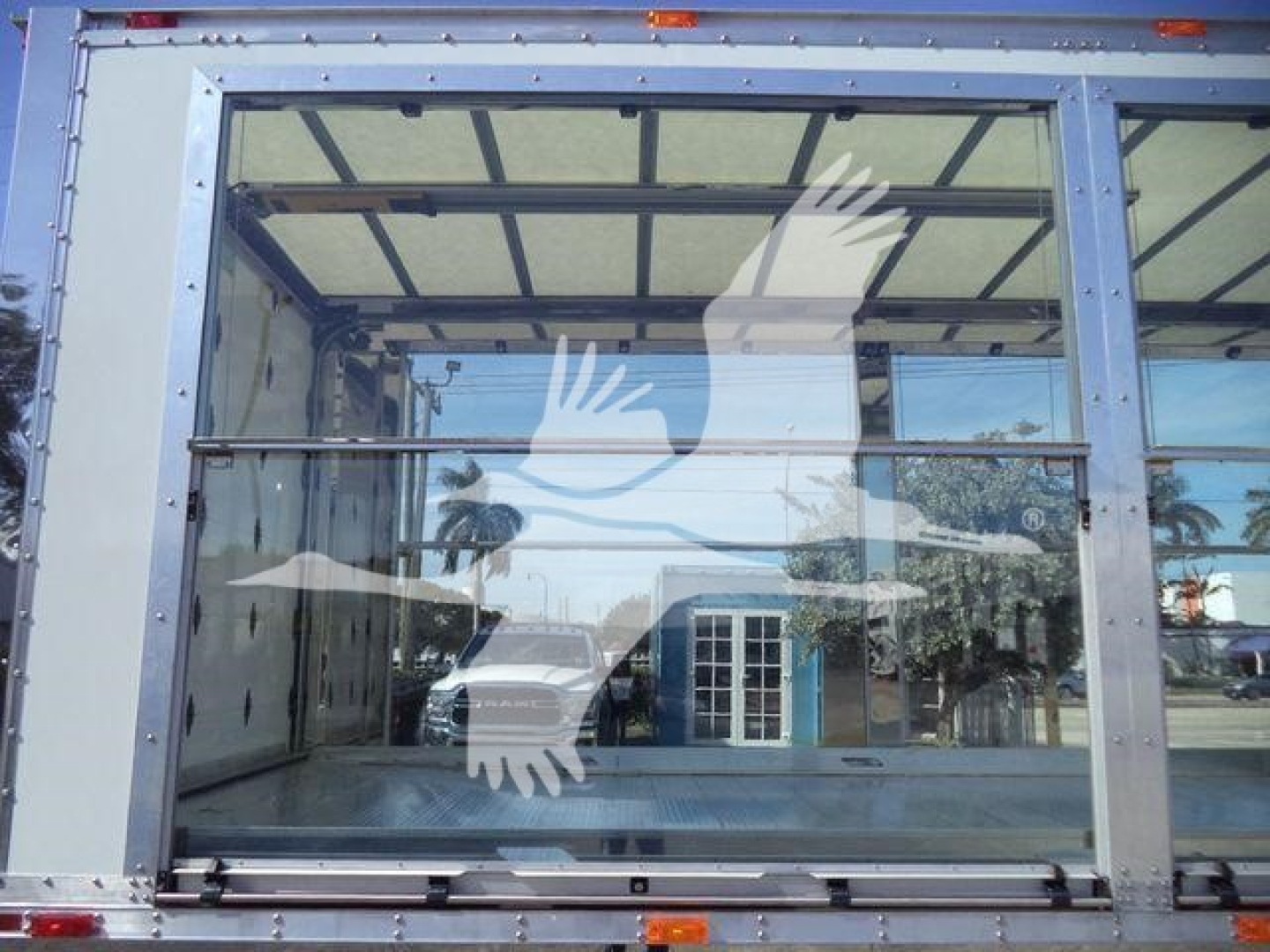 Truck cab or loading area with large glass rear door showing mirrored reflection; frame around glass panels; no visible branding or text.