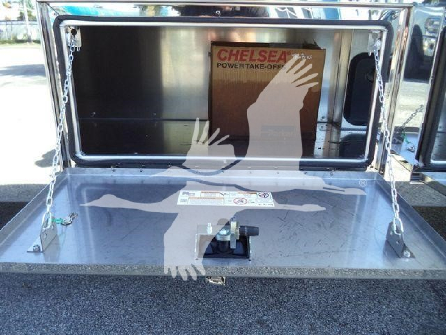 Truck bed of a Kenworth T280 rollback with open storage box showing CHELSEA power take-off decal inside.