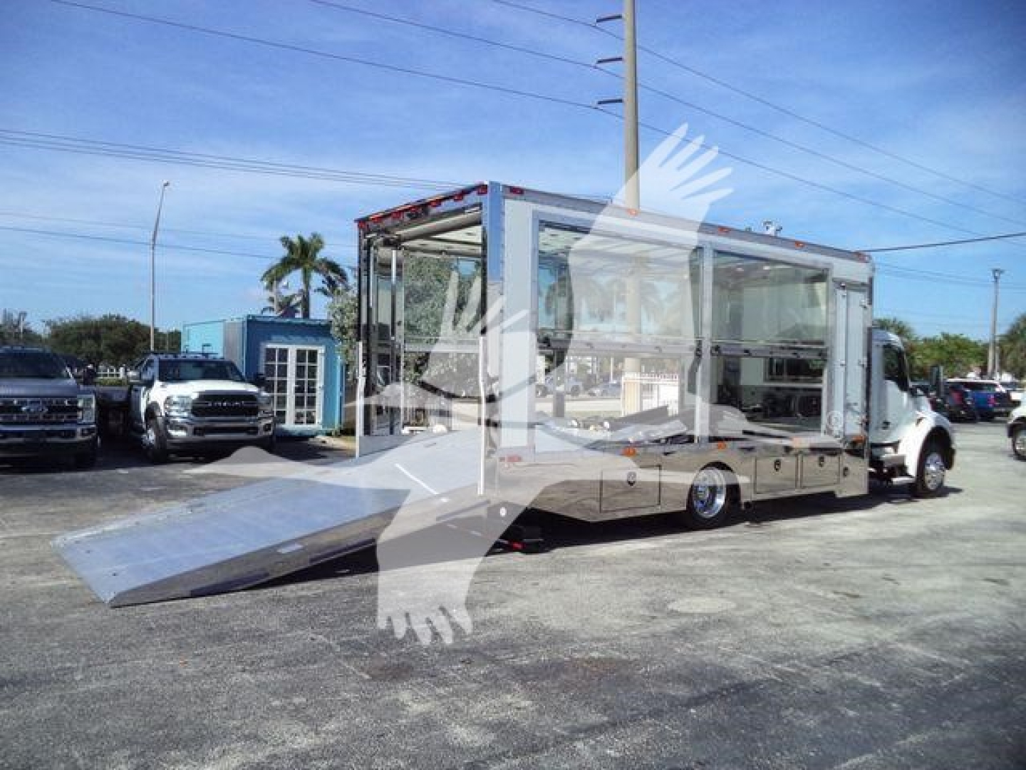Kenworth T280 rollback truck in a dealership lot with a long aluminum ramp extended; transparent image watermark overlays; cab and body in view