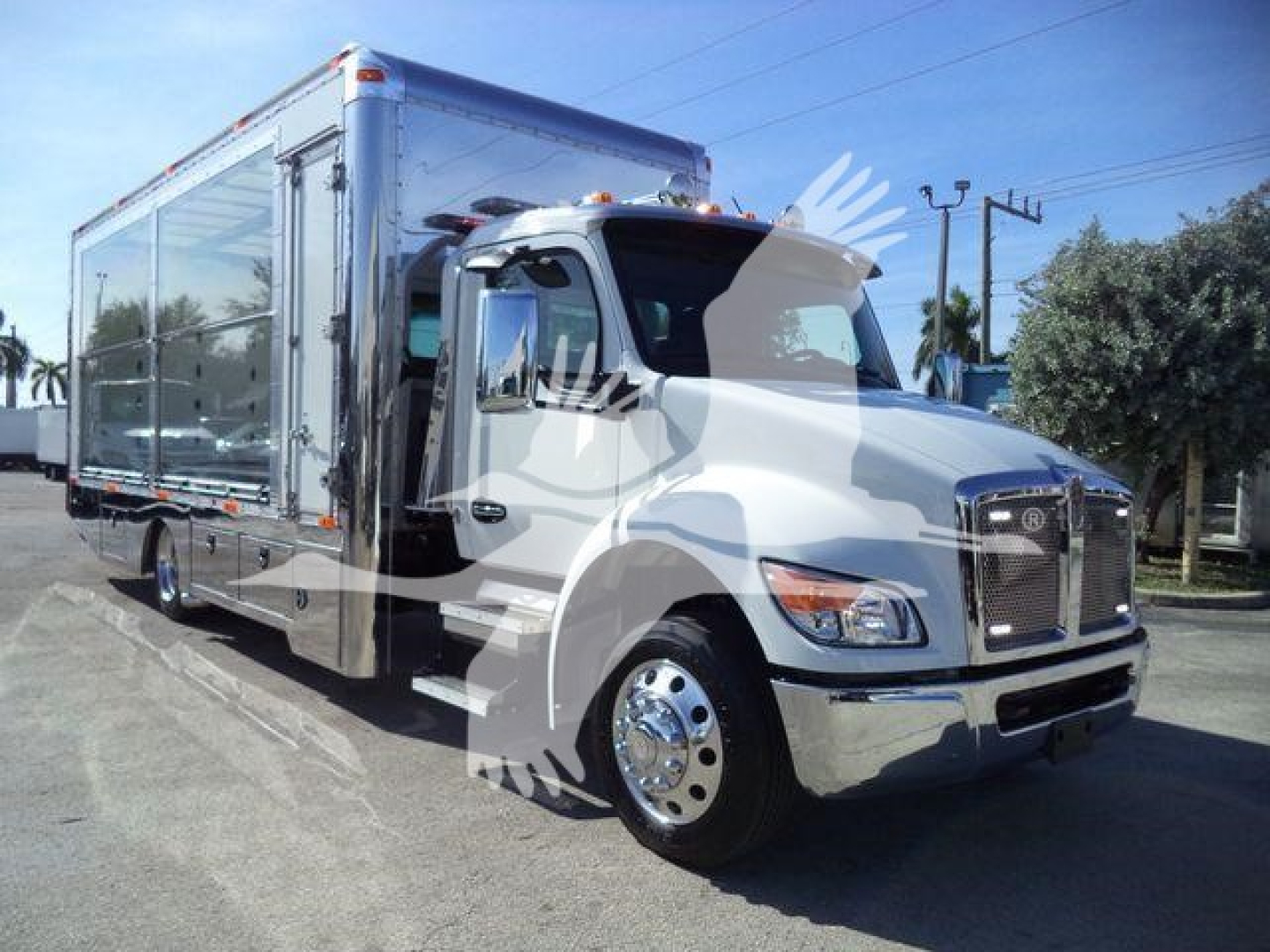 Kenworth T280 rollback truck in service view showing cab and large metallic cargo box on a low chassis.
