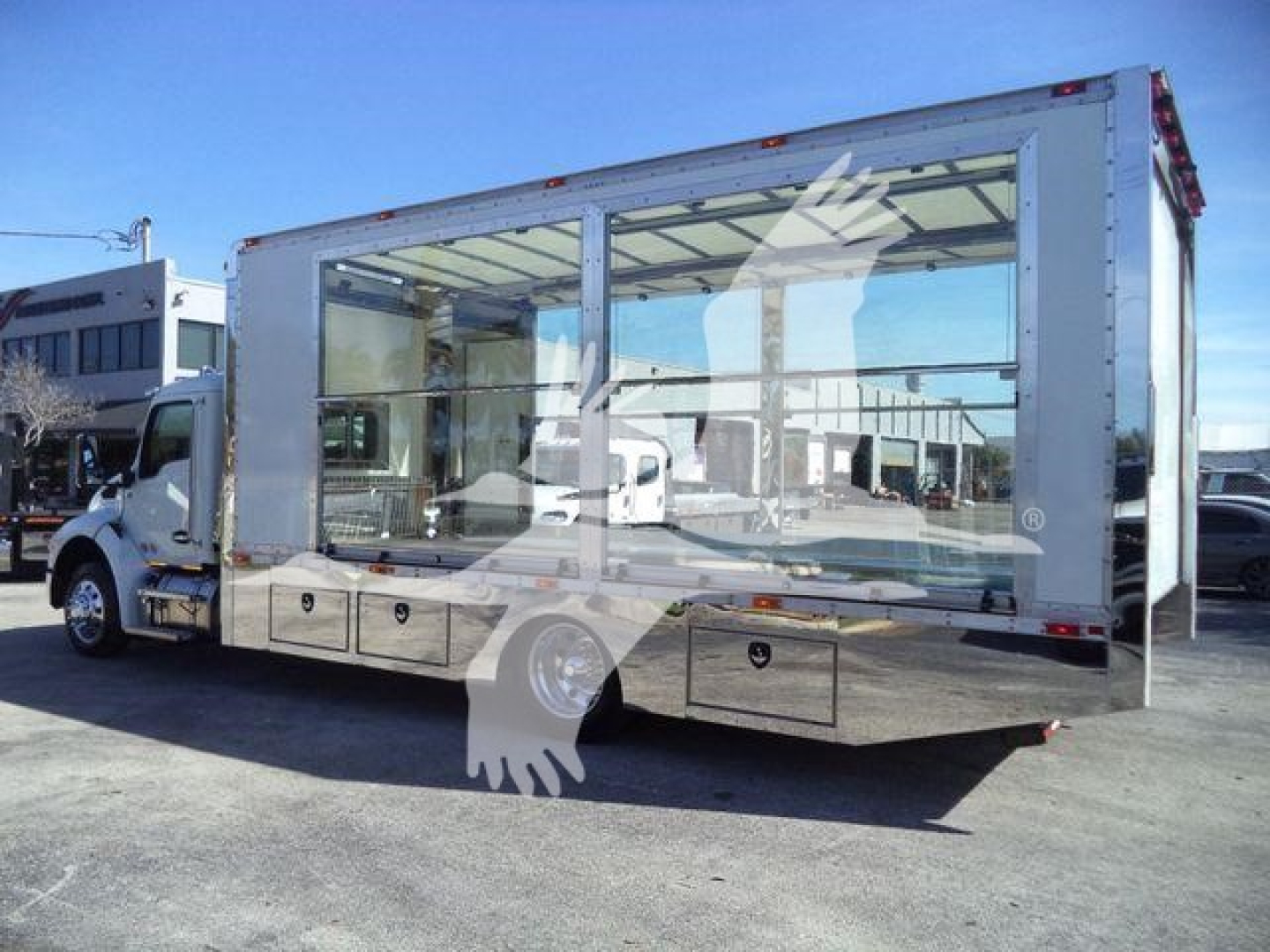 Kenworth T280 rollback truck with large rear cargo area and glass sides, side view showing chrome underbody storage drawers.