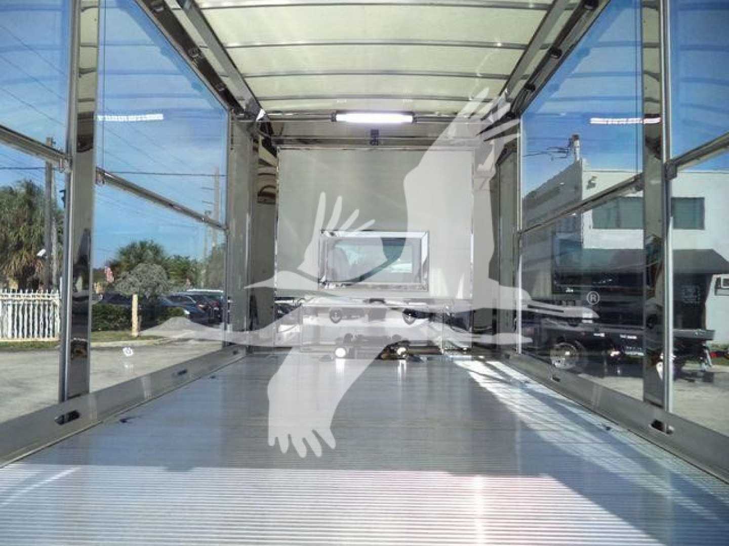 Truck bed area of a new Kenworth T280 rollback truck showing empty cargo bed with reflective metal floor and side rails.
