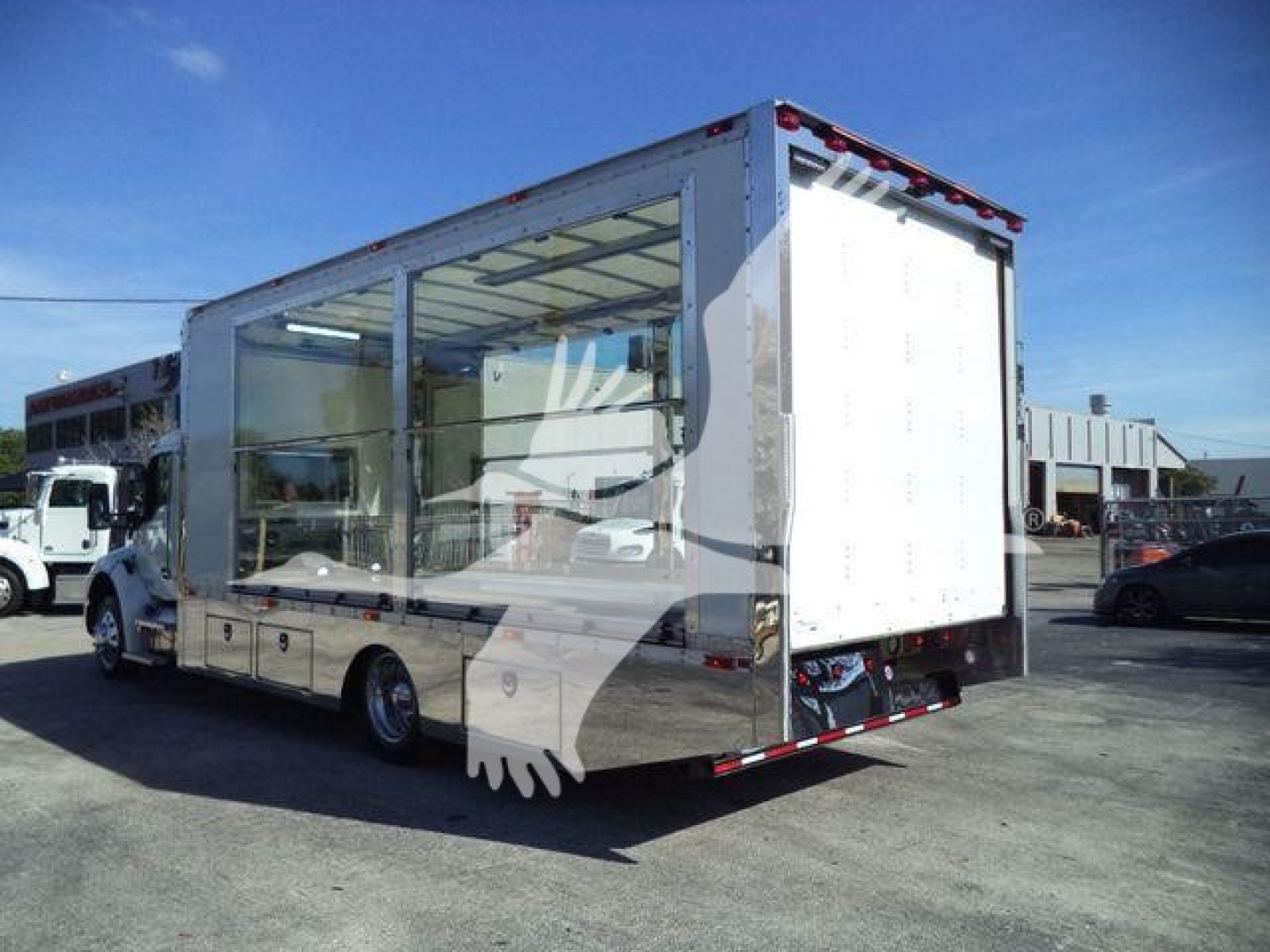Kenworth T280 rollback truck with open service body and glass sides, rear ramps down, stock number J40656FM, new unit.