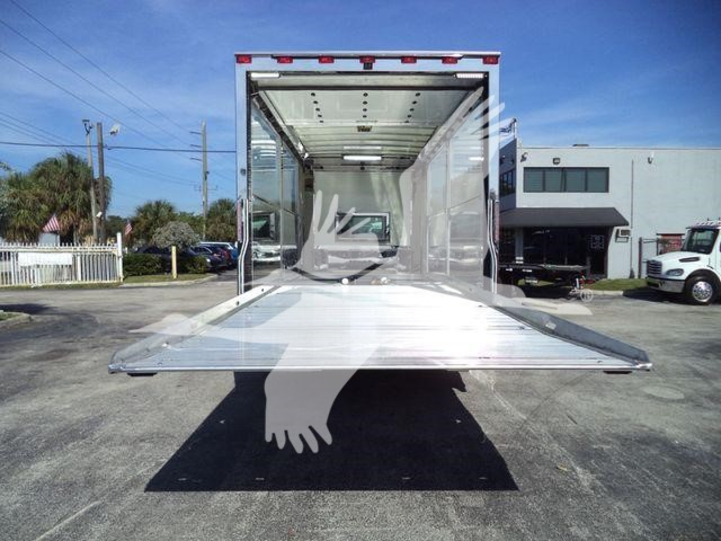 Rear view of a Kenworth T280 rollback truck with open cargo area and extended ramp.