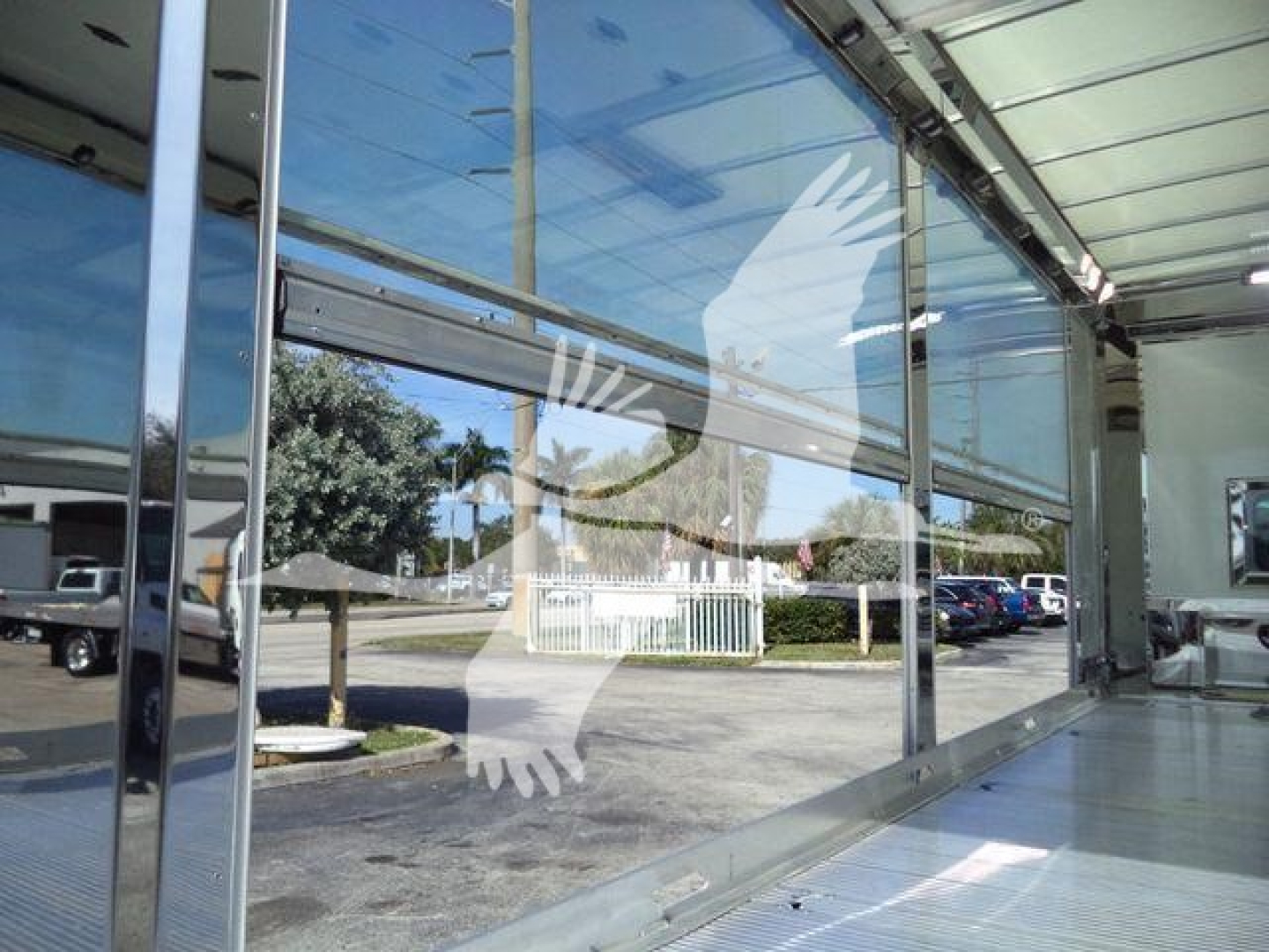 Kenworth T280 rollback truck showroom window view with reflection and logo silhouette on glass