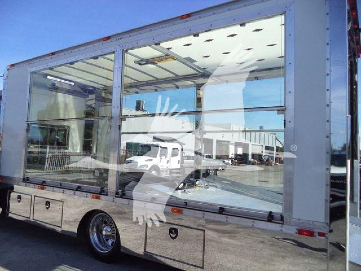 Kenworth T280 rollback truck side view showing large glass cargo area and chrome wheels.