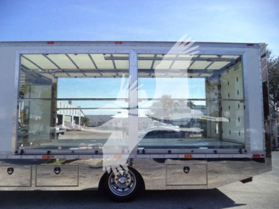 Kenworth T280 rollback truck cab rear view showing large aluminum storage compartments and dual rear doors.