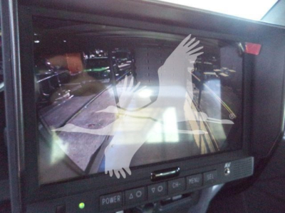 Kenworth truck dash display showing a touchscreen monitor with reflection and overlay; buttons labeled POWER, 4Q, MENU, VOLUME, etc.