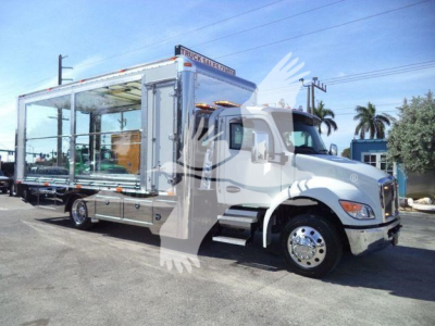 Kenworth T270/T680 style rollback truck with open-sided cargo bed and chrome wheels, front cab, stock number J40656FM, new condition.