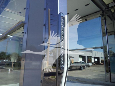 Truck body with vertical LED warning lights and chrome handle; reflection shows dealership exterior.