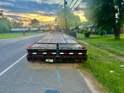 Big Tex flatbed trailer showing rear view with wooden deck and taillights.