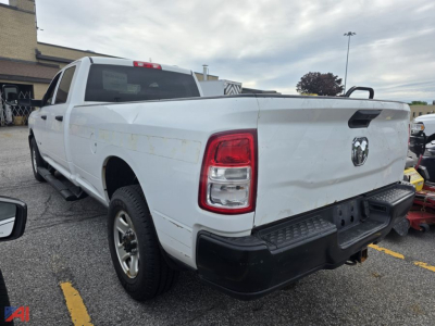 Rear view of a white 2019 Ram 3500 pickup truck in a lot with visible dents and a short bed; Ram logo on tailgate; black bumper and step; two-tone tail lights.