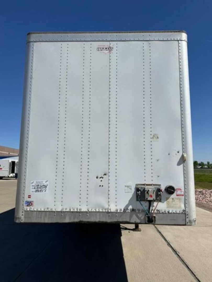Rear view of a 2014 Wabash trailer showing door with riveted aluminum skin and utility panel on lower right with connectors.