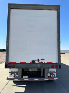 Trailer rear showing white back doors and taillights with bumper, no visible branding text