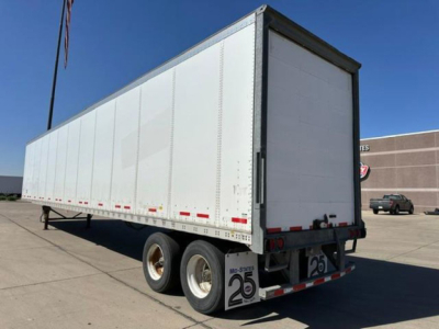 Trailer side and rear view of a 2014 Wabash van trailer showing white panel exterior, dual rear axles, and empty rear doors.