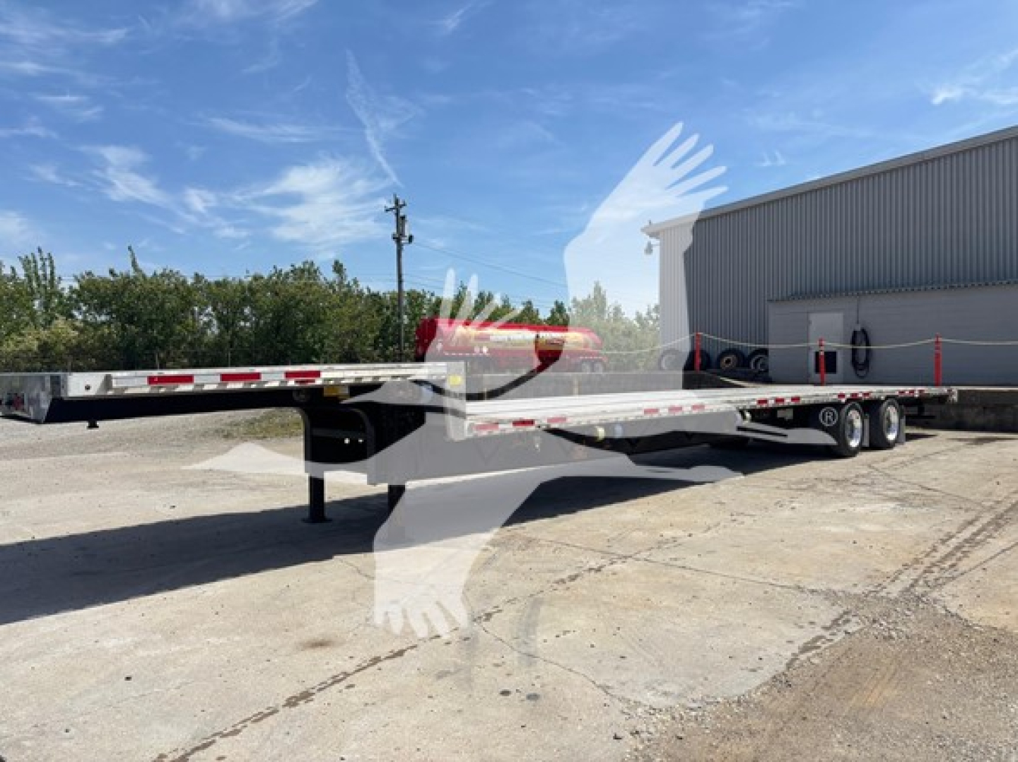 Transcraft D-Eagle II drop deck trailer showing flatbed with dual rear axles and gooseneck to the left.