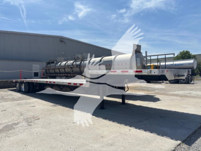 Transcraft D-Eagle II drop deck trailer profile showing long flatbed and gooseneck with mounted pneumatic cylindrical tank in background.