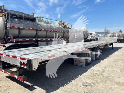 Transcraft D-Eagle II drop deck trailer showing long aluminum deck with dual rear axles and side marker lights.