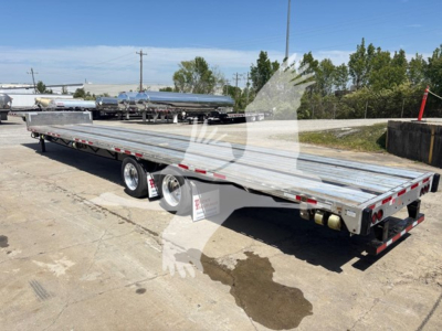 Trailer: 2023 Transcraft D-Eagle II drop deck trailer showing long flatbed with dual rear axles and metal decking.