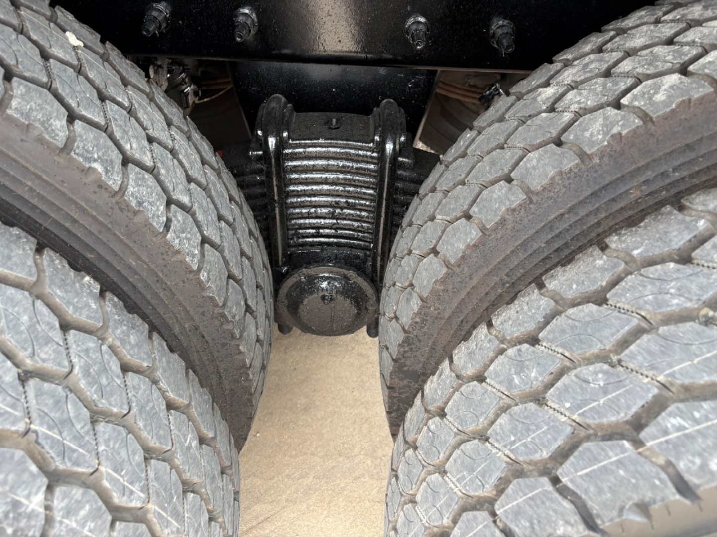Mack GR64F rear view showing suspension and dual rear axles with leaf springs and dual tires.