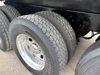 Mack GR64F truck rear dual axle tires showing dual wheels and tagless chrome rims under chassis