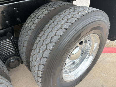 Mack GR64F truck dual rear wheels showing tire tread and chrome wheel.