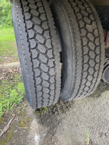 Two Hino truck tires side-by-side on a dual-axle setup with visible tread pattern.