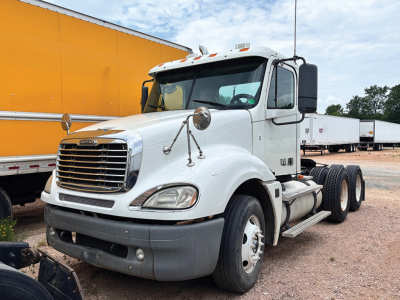 Truck cab and chassis from a Freightliner CL120 Columbia convention daycab showing front grille and dual rear axles.