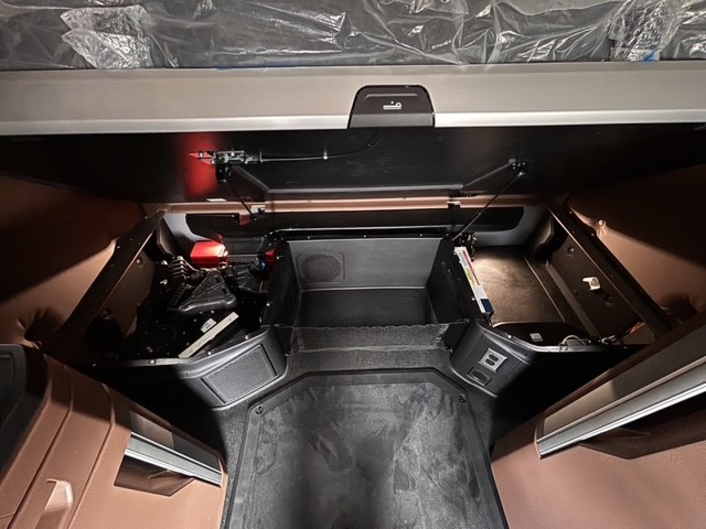 Truck cab interior of a 2027 Mack PR64T76H showing storage compartments and steps in sleeper area.