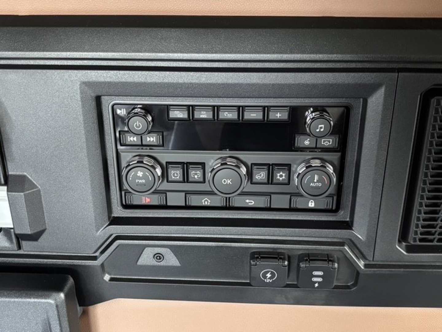 Dashboard control panel of a 2027 Mack PR64T76H truck showing climate and media control knobs and buttons.