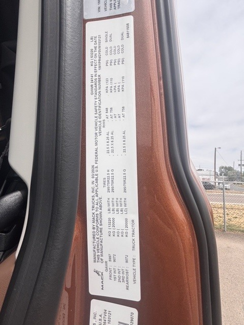Truck door jamb label with manufacturing and vehicle specifications for a Mack PR64T76H sleeper cab, including weight ratings and VIN information.
