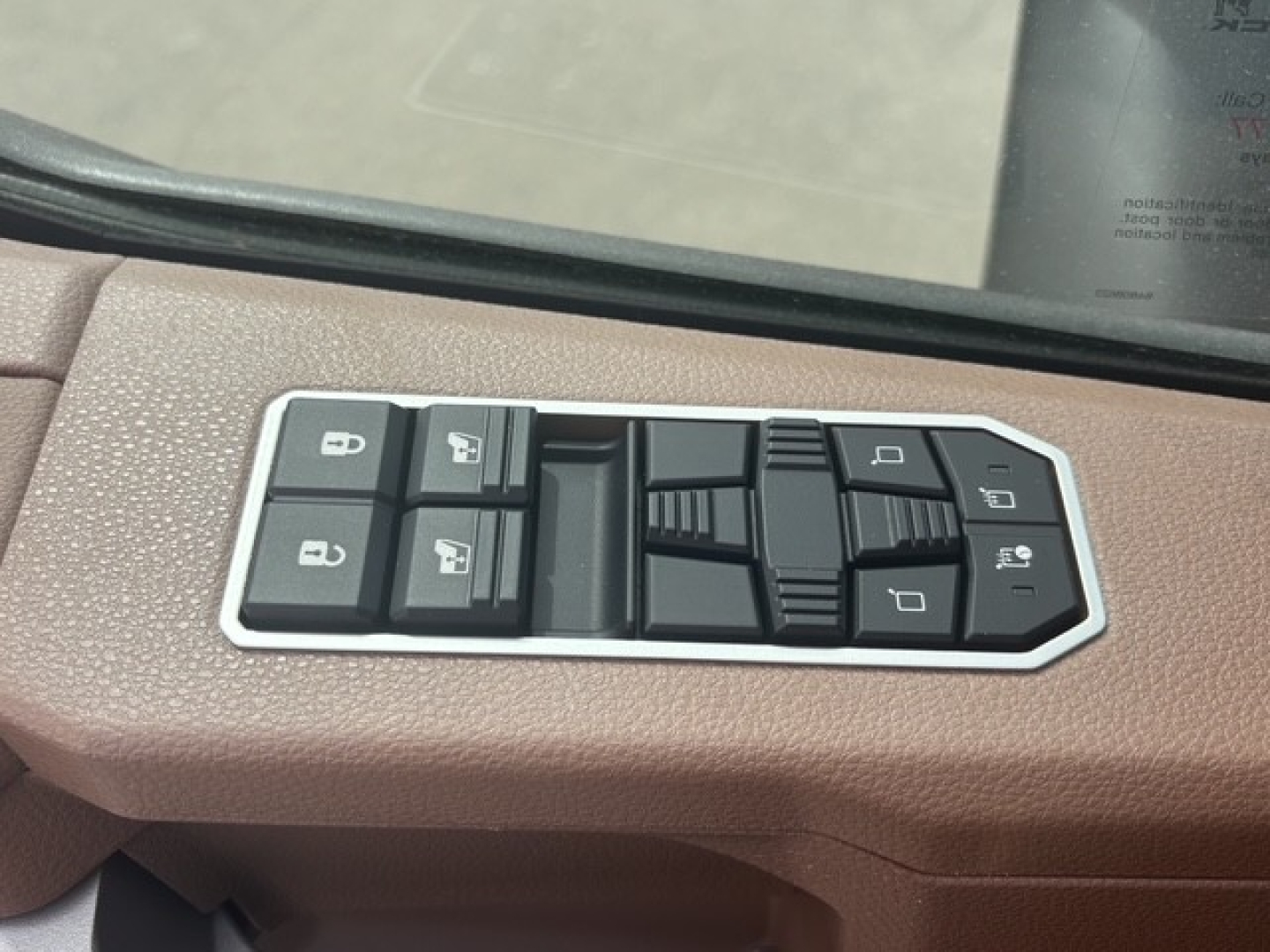 Interior door panel controls in a Mack PR64T76H showing window, mirror, and lock switch cluster.