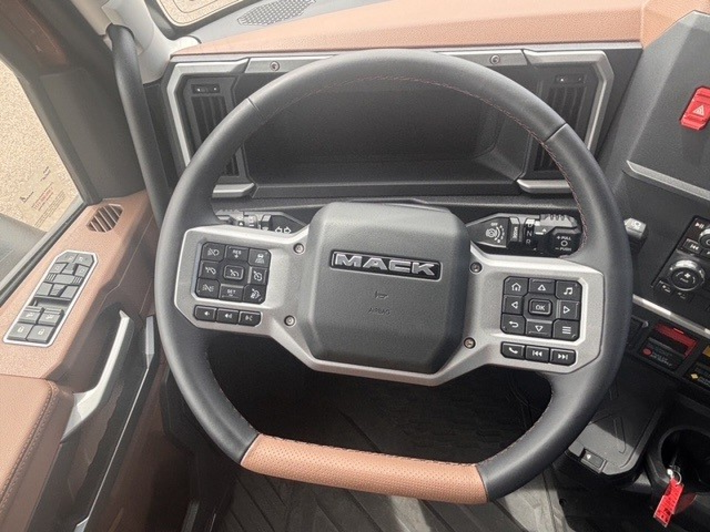 Mack PR64T76H truck steering wheel and dashboard view showing Mack logo on center hub and control stalks