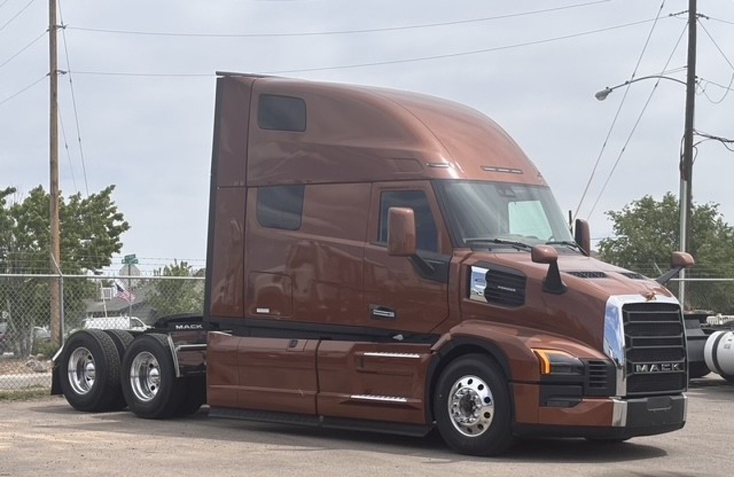 Mack PR64T76H tractor-trailer cab in brown showing aerodynamic sleeper with badge and chrome grille