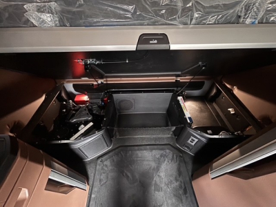 Truck cab interior of a 2027 Mack PR64T76H showing storage compartments and steps in sleeper area.