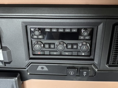 Dashboard control panel of a 2027 Mack PR64T76H truck showing climate and media control knobs and buttons.