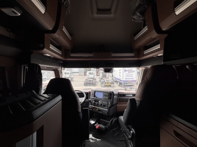 Mack PR64T76H truck cab interior view from front with dashboard and seats.