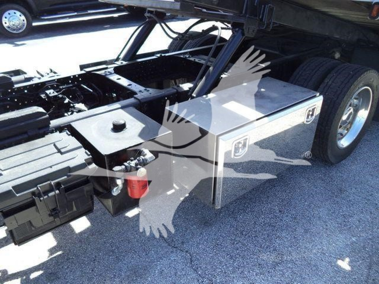 Isuzu NPR XD rollback truck chassis showing a silver toolbox mounted along the frame and dual rear wheels.