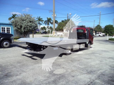Isuzu NPR XD rollback tow truck with a flatbed bed, side view showing the truck in a lot.