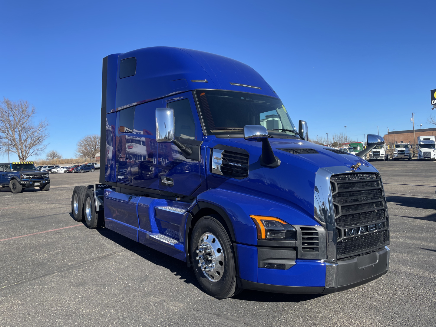 Blue 2026 Mack PR64T76H conventional sleeper truck with chrome grille and large blue cab, front left view.