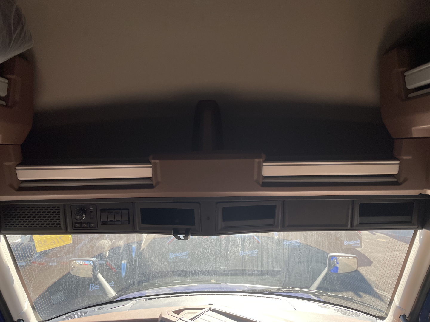 Mack PR64T76H truck cab interior showing instrument cluster and rearview mirrors, front windshield view.