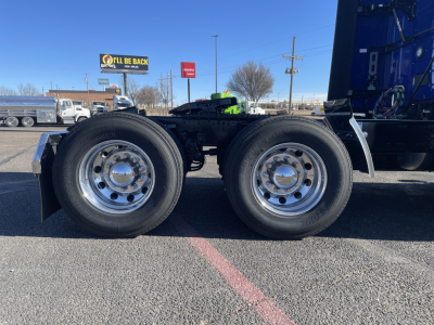 Dual rear drive wheels on a Mack PR64T76H heavy truck chassis showing chrome hubcaps and black tires; side of frame and components visible.