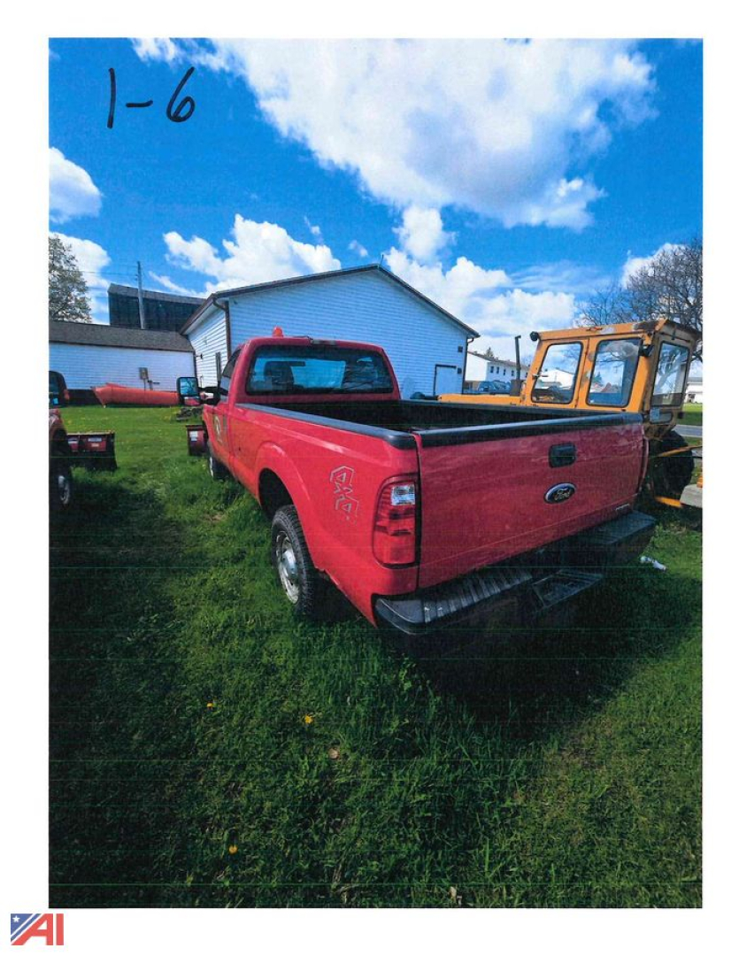 Red 2011 Ford F-250 Super Duty pickup truck with plow attachment in a grassy lot, rear view showing tailgate and bed.